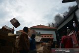 Karyawan dibantu warga menyelamatkan barang saat kebakaran gudang toko mainan di Jalan Abdurrahman Saleh Jombang, Jawa Timur, Jumat (10/1/2020). Sebanyak 2 unit mobil pemadam kebakaran dikerahkan ke lokasi untuk memadamkan gudang yang menyimpan berbagai mainan dan kembang api, penyebab kebakaran belum diketahui. Sementara kerugian diperkirakan mencapai ratusan juta rupiah. Antara Jatim/Syaiful Arif/zk