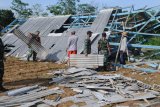 BERSIHKAN PUING BANGUNAN. Warga dibantu TNI membersihkan puing bangunan pasar yang ambruk akibat angin kencang di Desa Montok, Pamekasan, Jawa Timur, Sabtu (11/1/2020). Hujan lebat yang disertai angin kencang pada Jumat (10/1/2020) petang itu, menyebabkan 13 bangunan di Desa Montok dan Desa Lancar, rusak parah. Antara Jatim/Saiful Bahri/zk