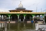 Seorang warga berada di dalam masjid yang berada di tengah genangan banjir rob atau banjir akibat air laut yang pasang di Desa Tompe, Kecamatan Sirenja, Kabupaten Donggala, Sulawesi Tengah, Minggu (12/1/2020). Banjir rob yang melanda permukiman warga itu disebabkan karena terjadinya penurunan permukaan tanah sedalam dua meter akibat gempa 7,4 SR yang berpusat di desa itu pada 28 September 2019. ANTARA FOTO/Basri Marzuki/aww.