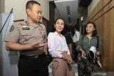 Kabid Humas Polda Jawa Timur Kombes Pol Trunoyudo Wisnu Andiko (kiri) mendampingi penyanyi Eka Deli (tengah) yang telah diperiksa sebagai saksi di Direktorat Reserse Kriminal Khusus (Ditreskrimsus) Polda Jawa Timur, Surabaya, Jawa Timur, Senin (13/1/2020). Eka Deli diperiksa sebagai saksi  selama sekitar sepuluh jam dengan 59 pertanyaan terkait kasus dugaan investasi ilegal 'MeMiles'. Antara Jatim/Didik/ZK