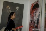 Pengunjung mengamati karya lukisan pada pameran yang bertajuk 