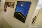 Pengunjung mengamati karya lukisan pada pameran yang bertajuk 