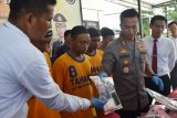 Kapolres Madiun AKBP Ruruh Wicaksono (kedua kanan) menunjukkan barang bukti di depan tersangka pengedar pil dobel L saat merilis pengungkapan sejumlah kasus di Mapolres Madiun, Jawa Timur, Jumat (17/1/2020). Polres Madiun menangkap empat orang tersangka pengedar pil dobel L, berinisial MIM, QU, RS dan NCH serta mengamankan barang bukti sebanyak 499 pil dobel L. Antara Jatim/Siswowidodo/zk.