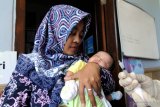 Bidan (kanan) bersiap menyuntikkan imunisasi pada bayi usia dua bulan di Pamekasan, Jawa Timur, Sabtu (18/1/2020).  Salah satu langkah guna mewujudkan capaian utama pembangunan kesehatan dan gizi masyarakat sekaligus salah satu pencegahan stunting (pertumbuhan bayi dengan tubuh pendek karena kurang asupan gizi) diantaranya adalah perluasan dan pemerataan cakupan imunisasi dasar lengkap. Antara Jatim/Saiful Bahri/zk