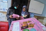 Bidan desa (kiri) menjelaskan pentingnya gizi seimbang guna mencegah stunting saat memberikan imunisasi di Pamekasan, Jawa Timur, Sabtu (18/1/2020). Salah satu langkah guna mewujudkan capaian utama pembangunan kesehatan dan gizi masyarakat sekaligus salah satu pencegahan stunting (pertumbuhan bayi dengan tubuh pendek karena kurang asupan gizi) diantaranya adalah perluasan dan pemerataan cakupan imunisasi dasar lengkap. Antara Jatim/Saiful Bahri/zk