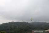 Penggiat Slackline berjalan melintasi tali sepanjang 200 meter saat Bandung Highline Festival di gunung Hawu, Padalarang, Kabupaten Bandung Barat, Jawa Barat, Senin (20/1/2020). Kegiatan tersebut merupakan olahraga yang menitikberatkan pada keseimbangan serta konsentrasi dan menjadi salah satu olahraga yang diminati generasi muda di sejumlah daerah. ANTARA JABAR/M Agung Rajasa/agr