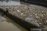 Seorang pemulung mengambil sampah plastik yang menutupi permukaan Sungai Cikeruh yang bermuara ke Sungai Citarum di Sukarame, Cileunyi, Kabupaten Bandung, Jawa Barat, Selasa (21/1/2020). Warga menyatakan, sampah rumah tangga yang terbawa luapan air akibat hujan deras pada Senin (20/1) sore tersebut dapat dibersihkan oleh pihak terkait karena menimbulkan bau yang tidak sedap dan dapat menimbulkan berbagai penyakit. ANTARA JABAR/Raisan Al Farisi/agr