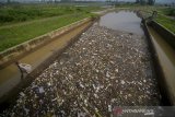 Seorang pemulung mengambil sampah plastik yang menutupi permukaan Sungai Cikeruh yang bermuara ke Sungai Citarum di Sukarame, Cileunyi, Kabupaten Bandung, Jawa Barat, Selasa (21/1/2020). Warga menyatakan, sampah rumah tangga yang terbawa luapan air akibat hujan deras pada Senin (20/1) sore tersebut dapat dibersihkan oleh pihak terkait karena menimbulkan bau yang tidak sedap dan dapat menimbulkan berbagai penyakit. ANTARA JABAR/Raisan Al Farisi/agr