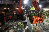 Alat berat mengangkut sampah dari sungai buntung, Waru, Sidoarjo, Jawa Timur, Selasa (21/1/2020) malam.  Badan Penanggulangan Bencana Daerah Sidoarjo (BPBD) Jawa Timur menerjunkan Tim Reaksi Cepat (TRC), Tim Relawan Penanggulangan Bencana (Trenggana) Satpol PP Jatim serta sejumlah instansi pemerintah dan TNI membersihkan penumpukan sampah dan enceng gondok yang menyumbat dan menghalangi aliran sungai tersebut. Antara Jatim/Umarul Faruq/zk