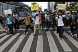 Sejumlah aktivis Koalisi Pejalan Kaki membawa poster kampanye dalam rangka Hari Pejalan Kaki Nasional saat lampu merah menyala di 'pelican crossing' Jalan MH. Thamrin, Jakarta, Rabu (22/1/2020). Mereka mengampanyekan kepada masyarakat untuk menaati peraturan lalu lintas, tidak merampas hak pejalan kaki, sekaligus meminta pemerintah untuk memberikan fasilitas yang lebih layak untuk keselamatan pejalan kaki. ANTARA FOTO/Aditya Pradana Putra/nym