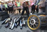 Polisi mengecek knalpot yang tidak memenuhi standard hasil operasi balap liar kepada media di Polresta,  Banyuwangi, Jawa Timur, Rabu (22/1/2020). Ratusan sepeda motor hasil operasi balap liar, diamankan Polresta Banyuwangi karena tidak memenuhi standard pabrikan serta aktivitas balapan dijalan umum yang meresahkan masyarakat dan menggangu pengguna jalan. Antara Jatim/Budi Candra Setya/zk