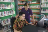 Perangkat desa mencari informasi pertanian untuk disebarkan ke masyarakat di Perpustakaan Desa Berbasis Teknologi Digital di Kantor Desa Grudo, Ngawi, Jawa Timur, Kamis (23/1/2020). Perpustakaan desa inovatif tersebut didirikan untuk mempermudah masyarakat setempat dalam mengakses pengetahuan serta informasi karena sebagian besar penduduknya adalah petani yang juga aktif menggunakan gawai. Antara Jatim/Ari Bowo Sucipto/zk.