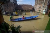 Warga melintasi banjir menggunakan perahu yang melanda Kampung Bojongasih, Dayeuhkolot, Kabupaten Bandung, Jawa Barat, Jumat (24/1/2020). Banjir luapan Sungai Citarum dengan ketinggian maksimal 1,5 meter tersebut diakibatkan oleh hujan deras pada Kamis (23/1) sore hingga malam hari di beberapa wilayah Bandung Raya dan menyebabkan ratusan warga mengungsi. ANTARA JABAR/Raisan Al Farisi/agr