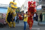 Warga menyaksikan atraksi Barongsai saat kelililing Pasar tradisional Keberagaman Umat, Peunayung, Banda Aceh, Aceh, Sabtu (25/1/2020). Atraksi Barongsai di pasar tradisional keberagaman umat  itu dalam rangka perayaan Tahun Baru Imlek. Antara Aceh/Ampelsa.