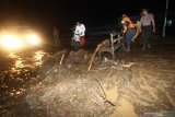 Polisi dan warga membersihkan lumpur akibat  banjir bandang di Petungsewu, Dau, Malang, Jawa Timur, Jumat (24/1/2020). Banjir bandang akibat meluapnya sungai Loh tersebut mengakibatkan dua orang pengendara motor luka-luka. ANTARA FOTO/HY Prabowo/Abs/zk