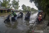 Seorang pengendara mendorong motornya yang mogok saat menerjang banjir yang menggenangi Jalan Cimincrang, Gedebage Bandung, Jawa Barat, Sabtu (25/1/2020). Genangan air dengan ketinggian 30 hingga 60 sentimeter  tersebut diakibatkan oleh hujan deras pada Jumat (24/1) sore hingga malam hari di beberapa wilayah Bandung Raya. ANTARA JABAR/Raisan Al Farisi/agr