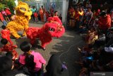 Warga menyaksikan atraksi Barongsai di kampung pecinan Tambak Bayan, Surabaya, Jawa Timur, Sabtu (25/1/2020). Peragaan busana pakaian tradisional tiongkok dan atraksi Barongsai meramaikan perayaan tahun baru Imlek 2571 di kampung itu. Antara Jatim/Didik/Zk