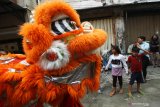 Warga menyaksikan atraksi Barongsai di kampung pecinan Tambak Bayan, Surabaya, Jawa Timur, Sabtu (25/1/2020). Peragaan busana pakaian tradisional tiongkok dan atraksi Barongsai meramaikan perayaan tahun baru Imlek 2571 di kampung itu. Antara Jatim/Didik/Zk