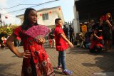 Warga menyaksikan peragaan busana di kampung pecinan Tambak Bayan, Surabaya, Jawa Timur, Sabtu (25/1/2020). Peragaan busana pakaian tradisional tiongkok dan atraksi Barongsai meramaikan perayaan tahun baru Imlek 2571 di kampung itu. Antara Jatim/Didik/Zk