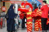 Pemain Barongsai memberikan bingkisan kepada penumpang pesawat di Terminal 2 Bandara Internasional Juanda, Surabaya, Jawa Timur, Sabtu (25/2/2020). Pertunjukan Barongsai dan Liang Liong di area publik terminal tersebut bertujuan untuk menghibur pengunjung bandara dalam rangka menyambut Tahun Baru Imlek 2571. Antara Jatim/Umarul Faruq/zk