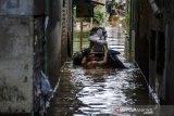 Warga berjalan membawa perabotan rumah melewati genangan banjir di Kawasan Andir, Kabupaten Bandung, Jawa Barat, Minggu (26/1/2020). Sedikitnya 40 ribu jiwa dan tujuh ribu rumah dari lima kecamatan di kawasan Bandung Selatan terdampak banjir akibat luapan Sungai Citarum dan intensitas curah hujan yang tinggi. ANTARA JABAR/Novrian Arbi/agr