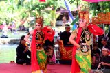 Pertunjukan tari Gandrung di atas kolam pemandian di Kampung tradisi dan adat (sidat) Jopuro di Taman Suruh, Banyuwangi, Jawa Timur, Minggu (26/1/2020). Tempat wisata yang dikelola oleh warga itu, menewarkan wahana pemandian dan pertunjukan kesenian tradisional. Antara Jatim/Budi Candra Setya/zk.