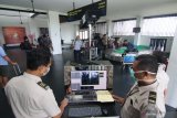 Petugas Kantor Kesehatan Pelabuhan (KKP) memeriksa penumpang yang baru tiba dengan alat deteksi suhu tubuh (thermoscan) di terminal kedatangan Bandara Internasional Banyuwangi, Jawa Timur, Senin (27/1/2020). Pemeriksaan  untuk mengantisipasi penyebaran virus corona itu, dilakukan karena Banyuwangi menjadi tempat wisata yang banyak dikunjungi wisatawan lokal dan internasional melalui Bandara. Antara Jatim/Budi Candra Setya/zk.