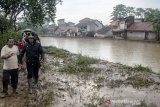 Gubernur  Jawa Barat Ridwan Kamil (kanan) berjalan di daerah aliran sungai saat meninjau lokasi terdampak banjir di kawasan Baleendah, Kabupaten Bandung, Jawa Barat, Selasa (28/1/2020). Kunjungan Gubernur Jawa Barat tersebut guna memberikan bantuan dan meninjau secara langsung lokasi pemukiman dan kondisi warga yang terdampak banjir di kawasan Bandung Selatan akibat luapan sungai Citarum. ANTARA JABAR/Novrian Arbi/agr