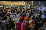 Sejumlah wisatawan asing asal China antre di konter lapor diri (check-in) Terminal Keberangkatan Bandara Hang Nadim, Batam, Kepulauan Riau, Selasa (28/1/2020). Agen biro perjalanan China memulangkan ratusan wisatawannya yang sedang berkunjung di Batam menyusul merebaknya wabah virus Korona, selain itu pihak Bandara Hang Nadim juga menghentikan sementara penerbangan dari China ke Batam sampai batas waktu yang belum ditentukan. ANTARA FOTO/M N Kanwa/nym.