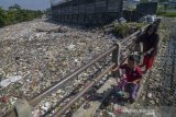 Warga melintas di samping sampah plastik di sungai Citepus yang bermuara ke sungai Citarum di Bojong Citepus, Cangkuang Wetan, Dayeuhkolot, Kabupaten Bandung, Jawa Barat, Selasa (28/1/2020). Warga mengatakan sampah tersebut telah satu bulan mengendap dan mereka berharap pemerintah setempat bisa segera membersihkannya karena dapat menimbulkan berbagai penyakit. ANTARA JABAR/Raisan Al Farisi/agr