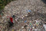 Seorang warga menemukan bendera merah putih di antara sampah plastik di sungai Citepus yang bermuara ke sungai Citarum di Bojong Citepus, Cangkuang Wetan, Dayeuhkolot, Kabupaten Bandung, Jawa Barat, Selasa (28/1/2020). Warga mengatakan sampah tersebut telah satu bulan mengendap dan mereka berharap pemerintah setempat bisa segera membersihkannya karena dapat menimbulkan berbagai penyakit. ANTARA JABAR/Raisan Al Farisi/agr