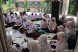 Siswa belajar di masjid sekolah yang ruang kelasnya tergenang air di SMPN 2 Tanggulangin Sidoarjo, Jawa Timur, Selasa (28/1/2020). Banjir yang menggenangi sejak sepekan di kawasan tersebut mengakibatkan sejumlah ruang kelas sekolah masih tergenang air, namun tak menyurutkan semangat siswa untuk tetap belajar. Antara Jatim/Umarul Faruq/zk