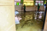 Guru mengangkut kursi yang ruang kelasnya tergenang air di SMPN 2 Tanggulangin Sidoarjo, Jawa Timur, Selasa (28/1/2020). Banjir yang menggenangi sejak sepekan di kawasan tersebut mengakibatkan sejumlah ruang kelas sekolah masih tergenang air, namun tak menyurutkan semangat siswa untuk tetap belajar. Antara Jatim/Umarul Faruq/zk