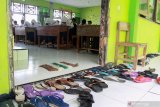 Siswa belajar di ruang kelas SMPN 2 Tanggulangin Sidoarjo, Jawa Timur, Selasa (28/1/2020). Banjir yang menggenangi sejak sepekan di kawasan tersebut mengakibatkan sejumlah ruang kelas sekolah masih tergenang air, namun tak menyurutkan semangat siswa untuk tetap belajar. Antara Jatim/Umarul Faruq/zk