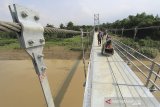 Warga melintasi jembatan gantung yang baru selesai dibangun di desa Gunungsari, Sukagumiwang, Indramayu, Jawa Barat, Rabu (29/1/2020). Kementerian PUPR Menargetkan pembangunan jembatan gantung baru untuk tahun 2020 sebanyak 148 unit dengan dengan total anggaran sekitar Rp 527 miliar. ANTARA JABAR/Dedhez Anggara/agr