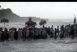 Umat Hindu menerobos ombak dalam Upacara Melasti di Pantai Tanah Lot, Tabanan, Bali, Kamis (30/1/2020). Upacara tersebut merupakan rangkaian ritual penyucian dan keharmonisan alam yang dipusatkan di Pura Batukaru, Tabanan, Bali yang digelar pada 29 Januari hingga 1 Februari 2020. ANTARA FOTO/Nyoman Hendra Wibowo/nym