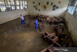 Sejumlah siswa membawa bangku untuk dibersihkan saat banjir melanda SMPN 1 Bojongsoang, Sapan, Kabupaten Bandung, Jawa Barat, Kamis (30/1/2020). Sebanyak 914 murid SMPN 1 Bojongsoang terdampak banjir sejak Jumat (24/1) yang menyebabkan kegiatan belajar mengajar dipindahkan melalui aplikasi di telefon pintar. ANTARA JABAR/Raisan Al Farisi/agr