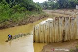 Warga menggunakan perahu rakit saat melintasi sungai Cibeet yang terpasang dinding turap (sheet pile) di Karawang, Jawa Barat, Jumat (31/1/2020). Balai Besar Wilayah Sungai (BBWS) Citarum menyatakan pemasangan dinding turap ditengah sungai Cibeet oleh oknum pengusaha Kabupaten Bekasi tersebut tidak memiliki izin dan dapat mempersempit bentuk sungai serta menyebabkan banjir. ANTARA JABAR/M Ibnu Chazar/agr