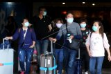 Sejumlah penumpang pesawat mengenakan masker di area Terminal Kedatangan Internasional Bandara Internasional I Gusti Ngurah Rai, Bali, Jumat (31/1/2020). Organisasi kesehatan dunia (WHO) menetapkan status darurat global terkait wabah virus Corona yang telah menyebar hingga sejumlah negara. ANTARA FOTO/Fikri Yusuf/nym.