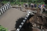 Warga melihat jembatan yang ambrol di Dau, Malang, Jawa Timur, Jumat (31/1/2020). Naiknya volume air sungai akibat tingginya intensitas hujan di kawasan tersebut dalam dua hari terakhir membuat jembatan penghubung antar desa tersebut ambrol. Antara Jatim/Ari Bowo Sucipto/zk