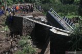 Warga melihat jembatan yang ambrol di Dau, Malang, Jawa Timur, Jumat (31/1/2020). Naiknya volume air sungai akibat tingginya intensitas hujan di kawasan tersebut dalam dua hari terakhir membuat jembatan penghubung antar desa tersebut ambrol. Antara Jatim/Ari Bowo Sucipto/zk