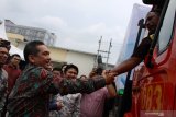 Menteri Perdagangan Agus Suparmanto (kiri) bersalaman dengan supir saat melepas ekspor produk makanan beku di PT Sekar Bumi Tbk, Sidoarjo, Jawa Timur, Jumat (31/1/2020). Produk makanan beku berupa udang, ebi furai, ebi katsu, bakso ikan, siomay, hakau dan spring roll tersebut di kirim ke Amerika Serikat, Jepang, Eropa dan Korea Selatan. Antara Jatim/Umarul Faruq/zk