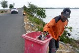 Petugas kebersihan memungut kantong dan botol plastik bekas di sepanjang jalan pantai wisata Kampung Jawa dan Pelabuhan Ulee Ulee Lheue, Banda Aceh, Aceh, Senin (3/2/2020). Pemerintah Kota Banda Aceh menghimbau pengunjung dan termasuk pedagang membuang sampah plastik bekas pada tempatnya, karena pemerintah daerah itu sudah menyediakan sejumlah bak sampah di beberapa titik sepanjang pantai wisata. Antara Aceh/Ampelsa.
