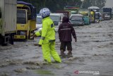 Petugas kepolisian mengatur lalu lintas saat terjadinya genangan air di Rancaekek, Kabupaten Bandung, Jawa Barat, Selasa (4/2/2020). Genangan air setinggi 30 - 60 cm yang terjadi di wilayah tersebut akibat drainase buruk sehingga membuat kemacetan panjang di jalur nasional menuju Garut, Tasik dan Jawa Tengah. ANTARA JABAR/Raisan Al Farisi/agr