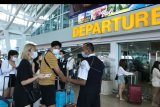 Petugas memeriksa tiket calon penumpang di Terminal Keberangkatan Internasional Bandara Internasional I Gusti Ngurah Rai, Bali, Selasa (4/2/2020). Pemerintah melalui Kementerian Perhubungan memutuskan penundaan penerbangan dari dan menuju seluruh destinasi di 