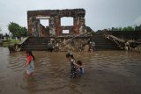 Sejumlah anak bermain air di area situs cagar budaya Keraton Kaibon yang terendam banjir di Kasemen, Serang, Banten, Selasa (4/2/2020). Banjir terjadi akibat kondisi drainase di lokasi itu mengalami pendangkalan dan jika tidak diperbaiki dikhawatirkan akan merusak struktur bangunan bersejarah tersebut. ANTARA FOTO/Weli Ayu Rejeki/nym.