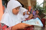 Sejumlah siswa meminjam buku dari mobil perpustakaan keliling di Sekolah Dasar Negeri Pasi Pinang, Kecamatan Meureubo, Aceh Barat, Aceh, Rabu (5/2/2020). Mobil perpustakaan keliling milik Dinas Perpustakaan dan Arsip Kabupaten Aceh Barat setiap hari mengunjungi sekolah-sekolah dengan tujuan untuk meningkatkan minat membaca buku di kalangan pelajar sekaligus untuk mengatasi keterbatasan perpustakaan di sekolah dengan memberi fasilitas pinjam dan membaca ditempat secara gratis. Antara Aceh/Syifa Yulinnas.