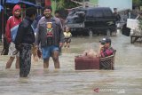 Warga melintasi genangan banjir di desa Bojongkidul, Susukan, Kabupaten Cirebon, Jawa Barat, Kamis (6/2/2020). Banjir akibat luapan sungai Wanakayam tersebut merendam sedikitnya 7 desa di kecamatan Susukan, Kabupaten Cirebon. ANTARA JABAR/Dedhez Anggara/agr