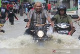 Warga melintasi genangan banjir di desa Bojongkidul, Susukan, Kabupaten Cirebon, Jawa Barat, Kamis (6/2/2020). Banjir akibat luapan sungai Wanakayam tersebut merendam sedikitnya 7 desa di kecamatan Susukan, Kabupaten Cirebon. ANTARA JABAR/Dedhez Anggara/agr