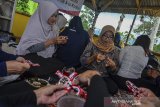 Wakil Ketua Persatuan Wanita Patra (PWP) Pertamina Geothermal Energy (PGE) Ira Eko Agung (kanan) belajar membuat tas berbahan limbah plastik kemasan bersama Kelompok Wanita Tani Mandiri saat kunjungan kerja di Saung Cinta Lembur Kuring, Desa Cinta, Kabupaten Garut, Jawa Barat, Kamis (6/2/2020). Kegiatan tersebut merupakan bagian dari program CSR PGE Area Karaha sebagai bentuk pemberdayaan perempuan mitra binaan dengan mengolah sampah plastik bernilai ekonomis diantaranya membuat kerajinan berbahan limbah plastik dan sampah organik dijadikan pupuk. ANTARA JABAR/Adeng Bustomi/agr